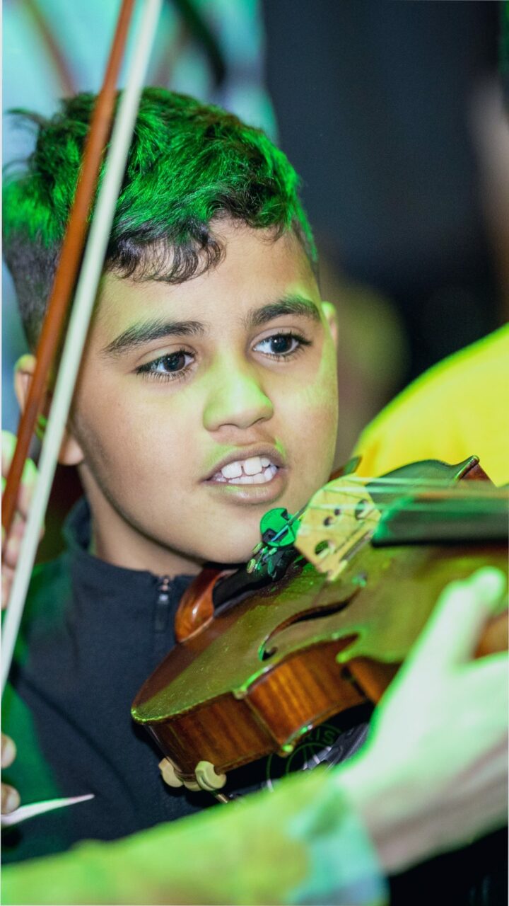 Leerling van taalschool krijgt les op een viool van het Ricciotti Ensemble – Muziek – ©Ananda Reijnen
